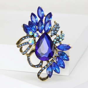 Elegant vintage blue crystal brooch featuring pear-cut stones and antique gold base