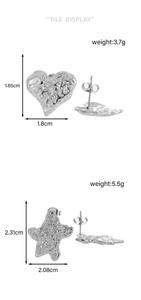 Detailed view of silver heart and star earrings with textured lava finish and measurements