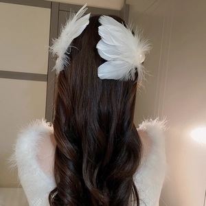 Detail of white feather hair clips with pearl accent on elegant wavy brown hair