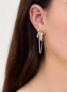 Close-up of bicolor titanium steel tassel chain earrings worn on a model's ear