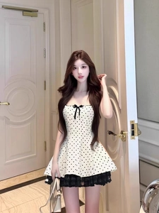 Detailed shot of French style polka dot dress featuring delicate lace hem and bow detail