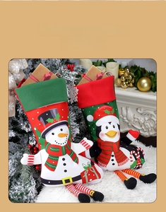 Detail of plush Christmas stockings featuring 3D snowman and penguin designs by a fireplace