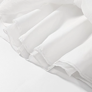 Macro shot of white chiffon fabric hem with wavy pleats and professional rolled edge finish