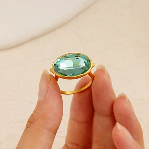 Minimalist gold stainless steel ring with a faceted oval green crystal gemstone for women