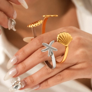 Adjustable starfish and seashell bangle set in gold and silver finish on model's wrist