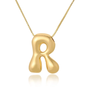 Macro shot of 3D bubble style capital letter R pendant on a thin gold chain necklace