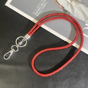 Close-up of luxury red rhinestone phone strap with silver lobster clasp and metal ring