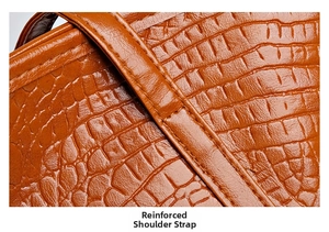 Close-up of reinforced shoulder strap stitching on brown crocodile pattern tote bag