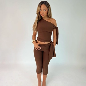 Detail of slim fit dark brown two-piece set with one-shoulder top and side lace-up shorts