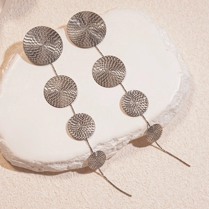 Boucles d'oreilles argentées à disques texturés en spirale et longs glands sur pierre