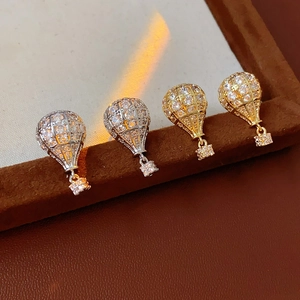 Vue macro de boucles d'oreilles montgolfière avec zircone en or et argent