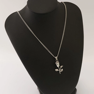 Silver stainless steel rose flower pendant necklace displayed on a black bust mannequin