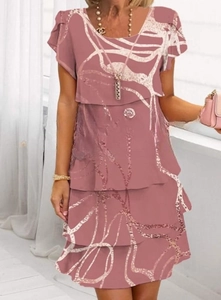 Detail of layered chiffon dress showing white artistic linear print and tiered hemline
