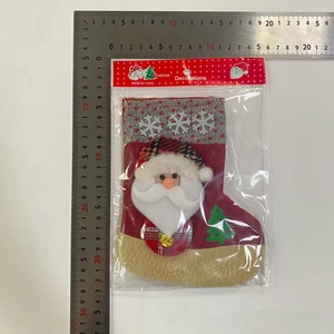 Détail d'une chaussette de Noël en tricot rouge avec motif Père Noël et mesure d'emballage