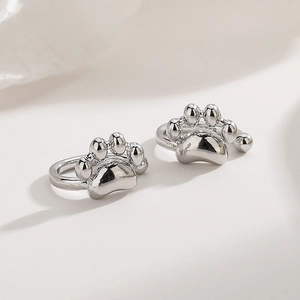Cute minimalist cat paw ear clips in shiny silver metal finish with 3D embossed design