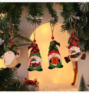 Close-up of four wooden Christmas gnome ornaments hanging on a festive tree branch