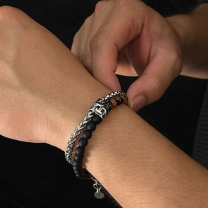 Close-up of double-layer stainless steel bracelet with tiger eye beads on wrist