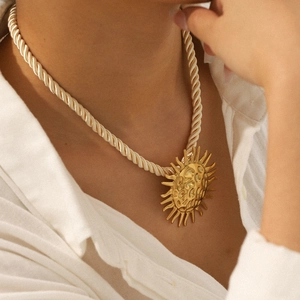 Golden sun pendant necklace with hammered texture on a beige braided rope chain for women