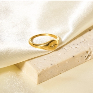 Detail of vintage gold hexagram signet ring on stone and silk background