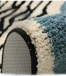 Close-up of thick blue-striped absorbent bath mat showing non-slip backing and soft fiber