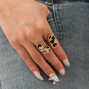 Edelstahl-Ringset mit Leopardenmuster in Goldoptik auf blauem Jeansstoff Hintergrund