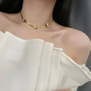 Gold butterfly snake chain necklace on female model neck with three charms