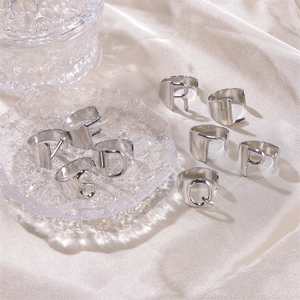Silver retro English letter open rings in various styles on a soft silk background
