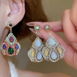 Macro detail of Bohemian teardrop earrings with colorful crystals and opal blue stones