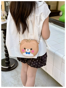 Rear view of a child wearing a khaki bear-shaped crossbody bag with gold chain strap