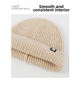 Primer plano de gorro de lana beige mostrando tejido de punto acanalado y ala doblada