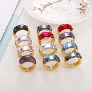 Close-up of semi-wrapped gemstone rings in various colors with golden titanium bands