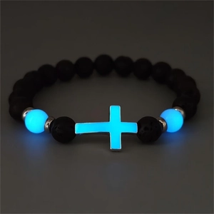 Leuchtendes blaues Kreuz und Perlen auf schwarzem Lavastein-Armband im Detail gesehen