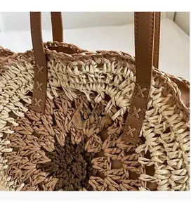 Detailed close-up of woven paper straw beach bag featuring multi-color floral pattern