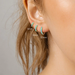 Detailed view of 6mm 8mm and 10mm gold huggie earrings with turquoise beads on model