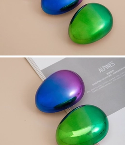 Close-up of portable detangling hairbrushes with metallic blue-purple and green finish