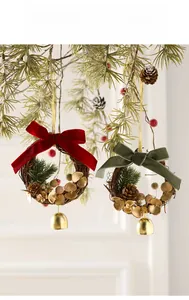 Detail eines Weihnachtskranzes mit roter Samtschleife, Tannenzapfen und Goldglöckchen