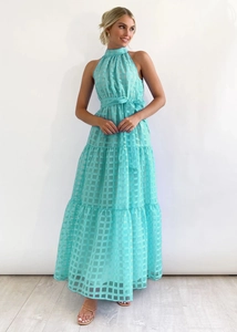 Detail of turquoise tiered maxi dress featuring textured plaid fabric and waist tie ribbon