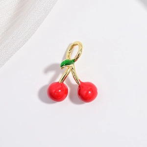 Detailed view of red cherry pendant with green leaves and gold plated enamel finish