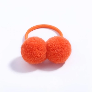 Detailed view of elastic hair tie featuring two vibrant orange plush pom-pom balls
