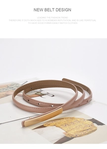 Detailed view of beige slim leather belt with a minimalist gold buckle on a magazine