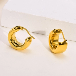 Detailed view of classic golden stainless steel C-hoop earrings on minimalist background