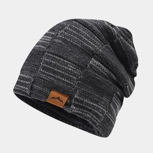 Detail of mixed grey knit beanie showing chunky texture and brown leather peak patch