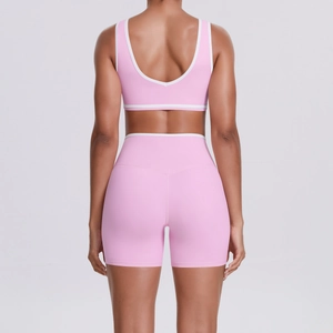 Rear view of pink cross-waist yoga set with white trim and U-shaped back design