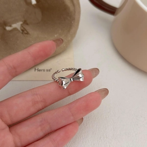 Detail of 925 sterling silver bow ring with twisted band on female hand