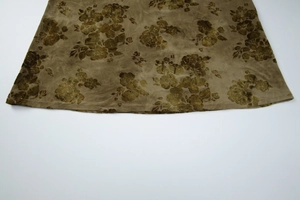 Detailed macro view of the tie-dye floral pattern on the velvet maxi dress hemline