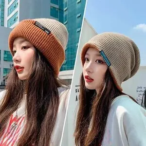 Detail of two-tone knit beanie featuring orange and beige contrast with 1988 fabric label