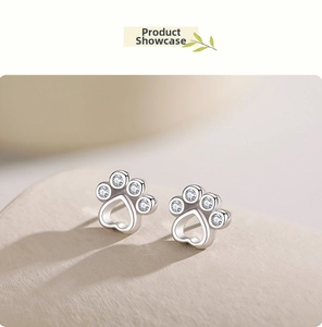 Close-up of S925 silver paw print earrings with heart cutout and sparkling cubic zirconia