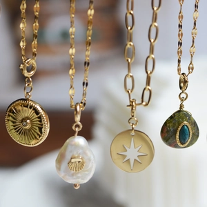 Detailed close-up of French vintage gold pendants featuring natural stones and pearls