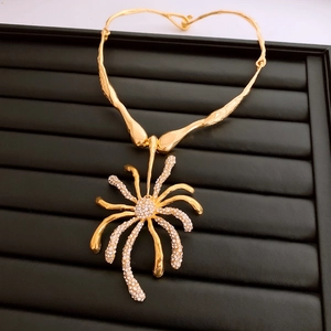 Détail du pendentif araignée doré avec pavé de cristaux blancs sur chaîne texturée