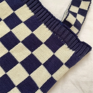 Detailed macro view of the checkered knit tote bag showing blue fabric texture and seams